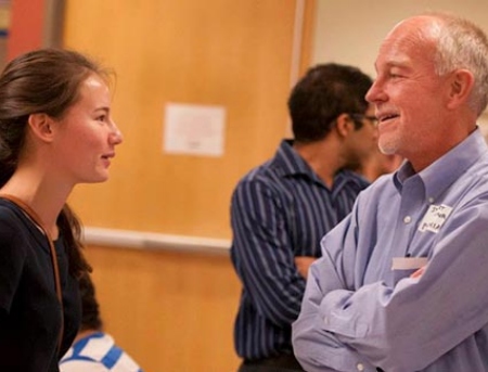 student and professor standing and having a conversation