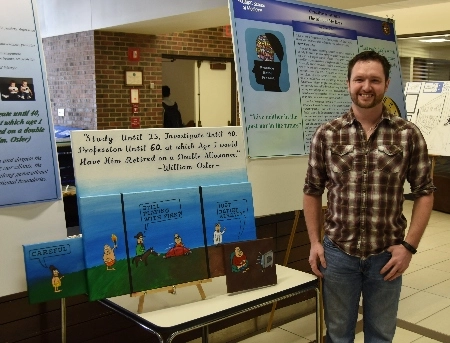 Student standing in front of presentation, smiling at camera