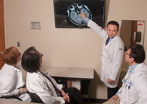 Faculty and students studying discussing a brain scan. 