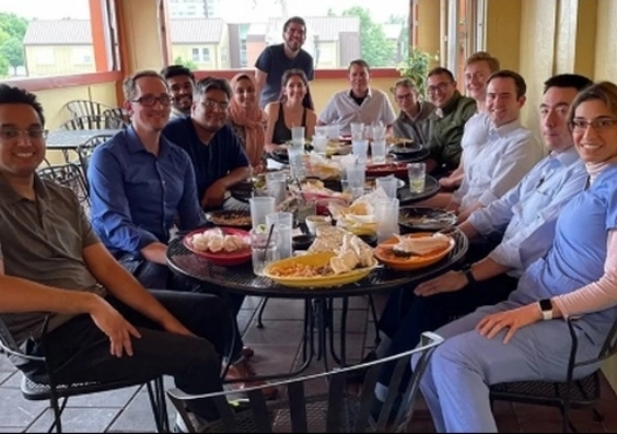 Neurology residents smiling while having lunch together at a restaurant.