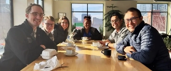 Residents smiling at a table during team lunch.