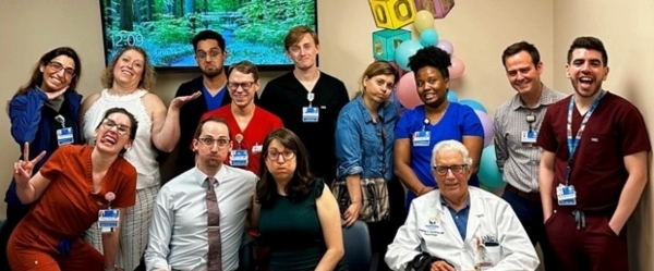 Residents posing and smiling together while dressed in their scrubs.