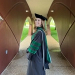 Portrait of Lauren Farley, OBYGN resident, posing in her graduate cap and gown.