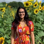 Portrait of Anmol Hans, OBGYN resident, in a field full of flowers.