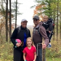 Julie Vircks and her family posing for a photo while on a family hike with her two children and husband.