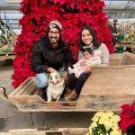 Portrait of Henry Mishek, OBGYN resident, with his wife and child in a giant sled during the holiday season.