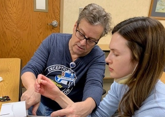 An OBGYN student receiving instruction from a faculty member. 