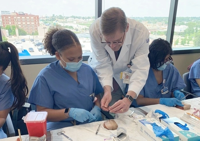 An OBGYN faculty member practices a simulated procedure with a resident. 