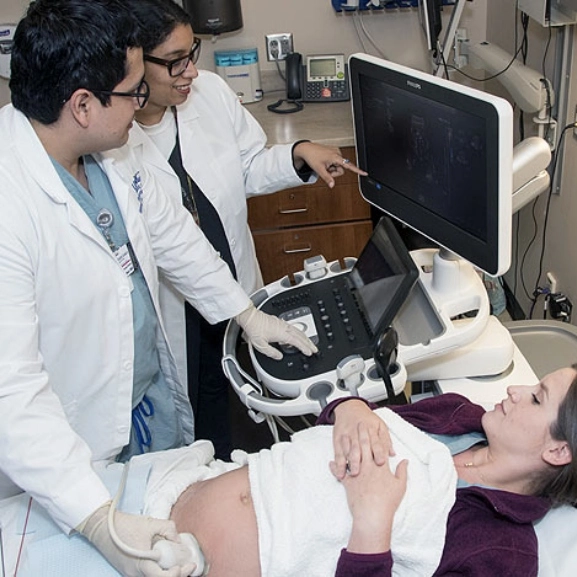 OBGYN fellows perform and sonogram on a patient.