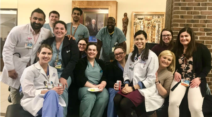 OBGYN residents posing for a group photo. Some are dressed in lab coats. Some in casual clothes.