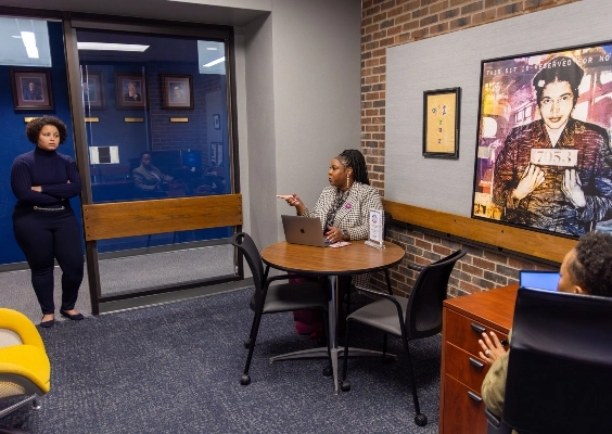 Office of the Learning Environment - Inclusive Excellence staff talking in the office.