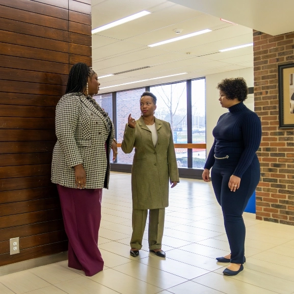 Inclusive excellence staff and leadership talking in a lobby at the UMKC School of Medicine.