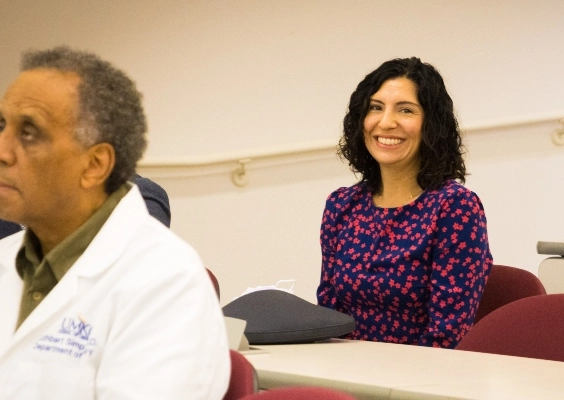 A faculty member smiling during the faculty awards presentation at the UMKC School of Medicine.