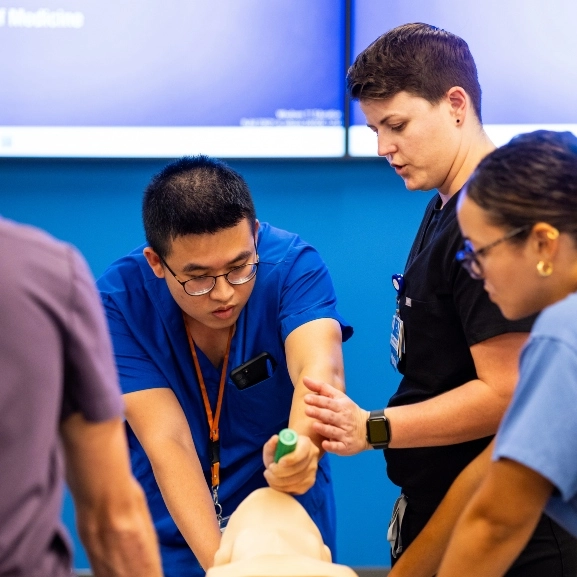 A medical student receiving instruction from a faculty member during an airway workshop.