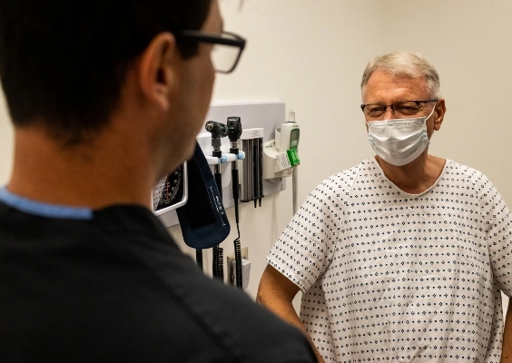 A School of Medicine resident talks to a patient in a respectful manner.