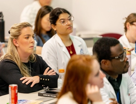 Surgery residents listening intently during a class lecture.