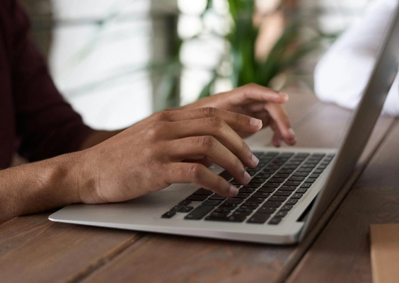 Closeup of a person typing on the computer to report mistreatment.