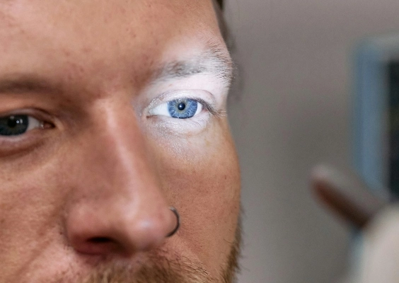 Closeup of a patient getting a light shined in his eye during an exam.