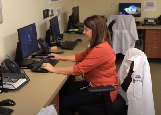 An Ophthalmology resident working on a computer in the office.