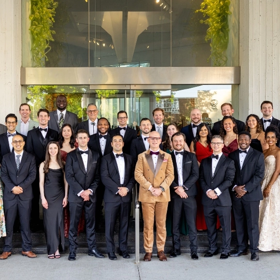 Looking up the faces of a group of orthopaedic surgeons in an operating room.