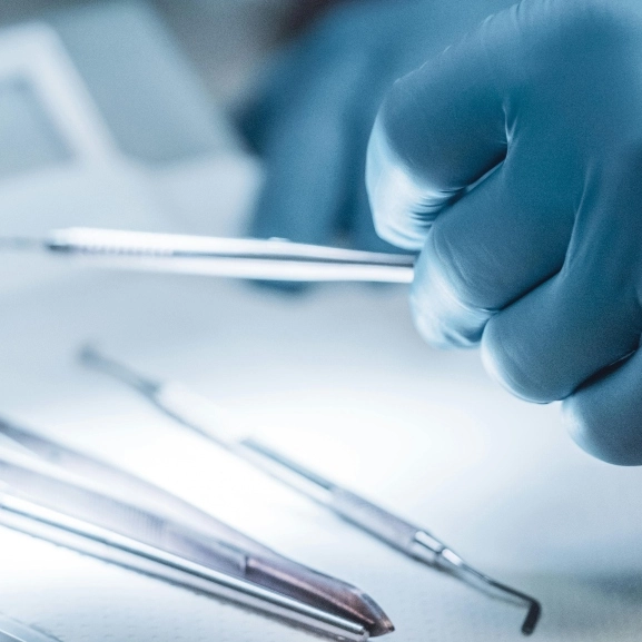 Close up of a surgeon's hands holding a tool. 