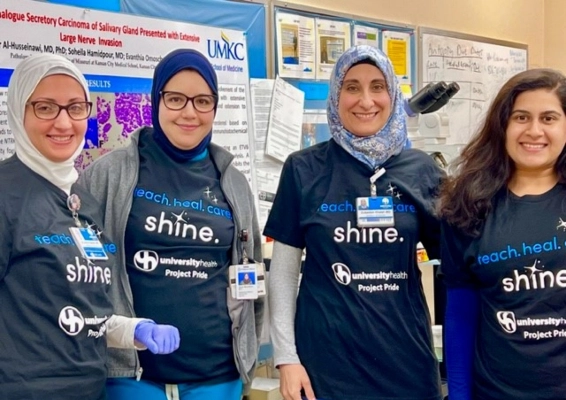 Four pathology students pose for a photo at a hospital event.