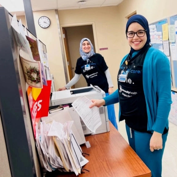 Two pathology residents pose while sorting medical paperwork.