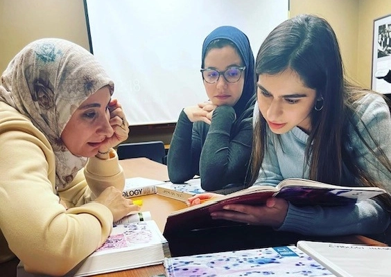 Three pathology residents studying a textbook together.