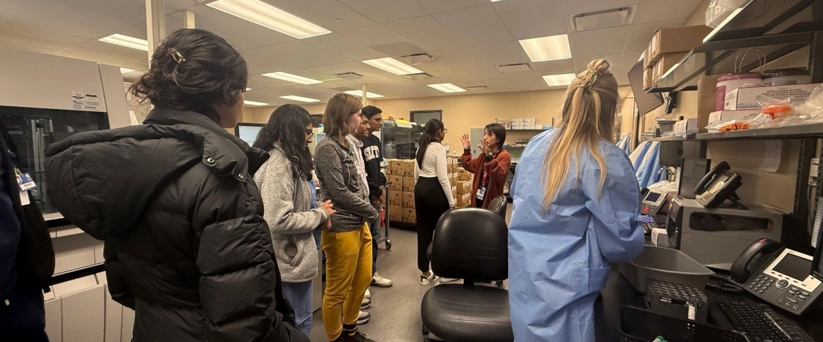 Pathology Interest Group students listen to a instructor in the lab.