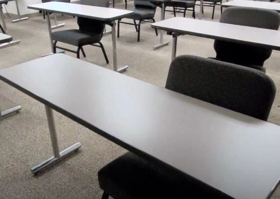 Rows of empty desks in a psychiatry didactics room.