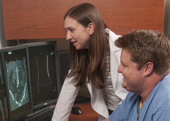 Two people look at computer monitors