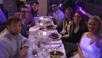 Group sits together at dining table.