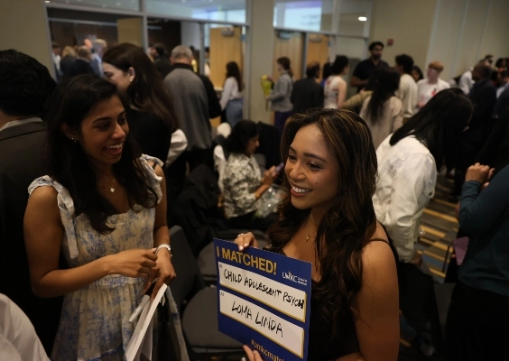 Medical student holds up sign with match location.