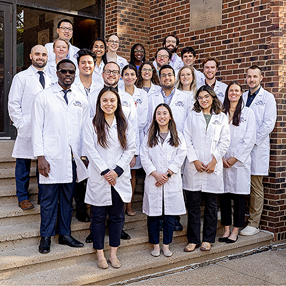 Residents in white coats in group photo