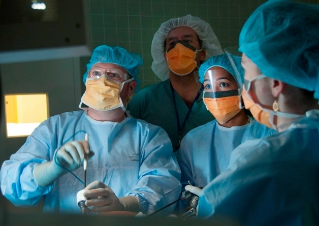 Surgery instructors and residents work together in the operating room.