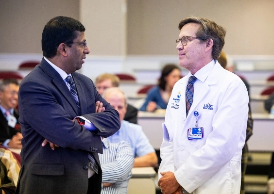 Two faculty members talking intently at a faculty event.