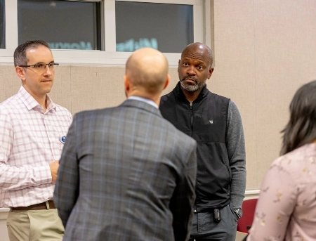 Two School of Medicine faculty members talk during a lecture to surgery residents.