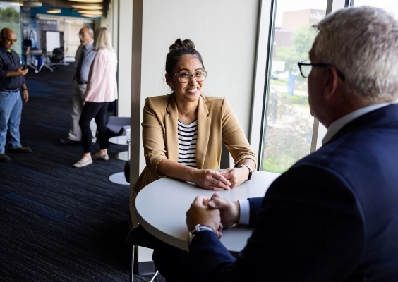 Human Resources staff meeting with a faculty member inside a modern administrative building.