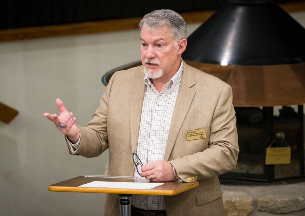 A faculty member giving a lecture at a podium.