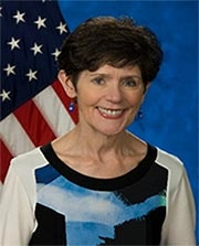 Portrait of Dr. Carolyn Clancy, M.D., MACP with an American flag hanging in the background.