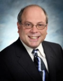 Portrait of Dr. Michael Handler, M.D. in a suite and tie.