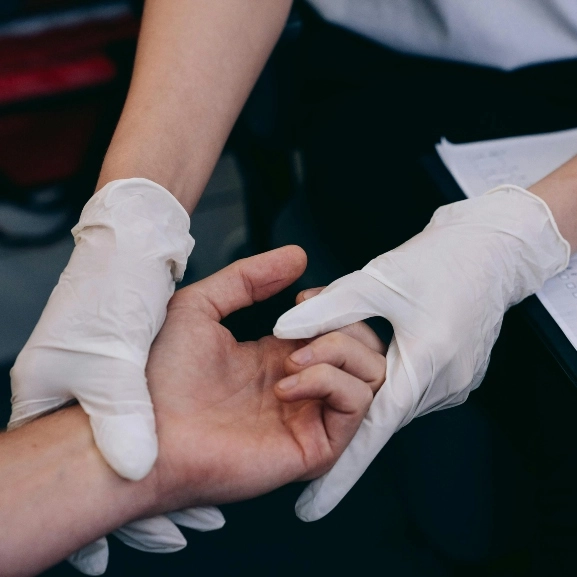 A doctor holding a patient's hand in comfort.